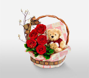 Teddy bear 6 inches with 5 short stems of red roses in the same Basket